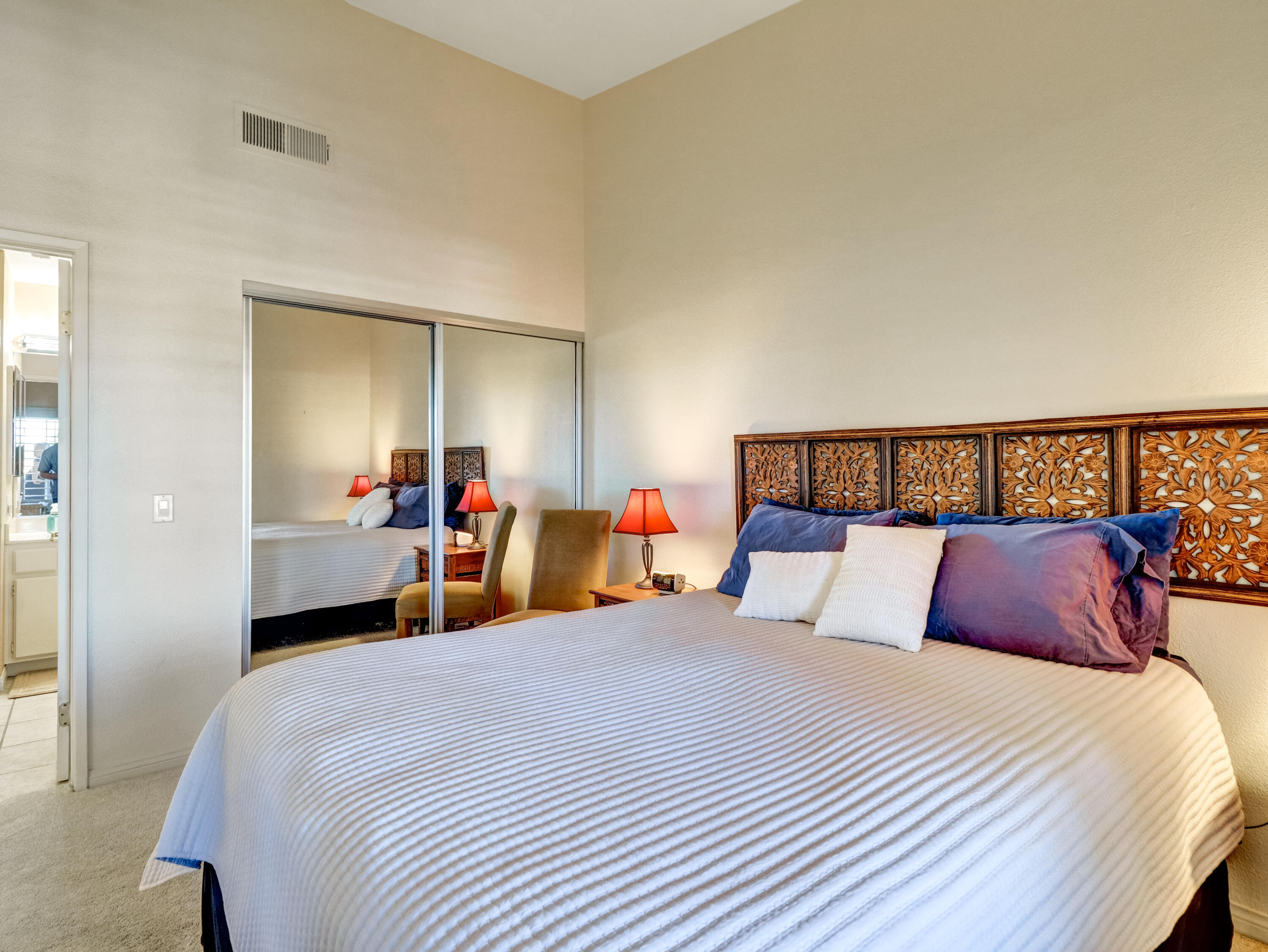 55393 Winged Foot La Quinta, CA 92253 - Photo 18 of 29 a bedroom with a large bed and a large mirror