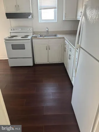 a view of a kitchen with white cabinets and white appliances