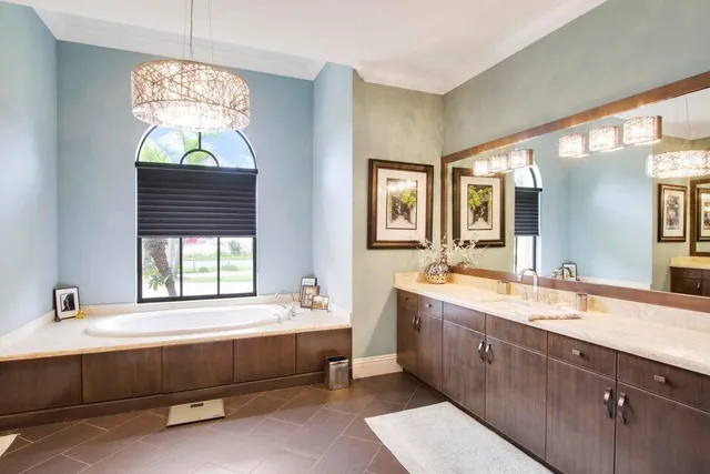 a spacious bathroom with a tub double sink windows and dual sinks