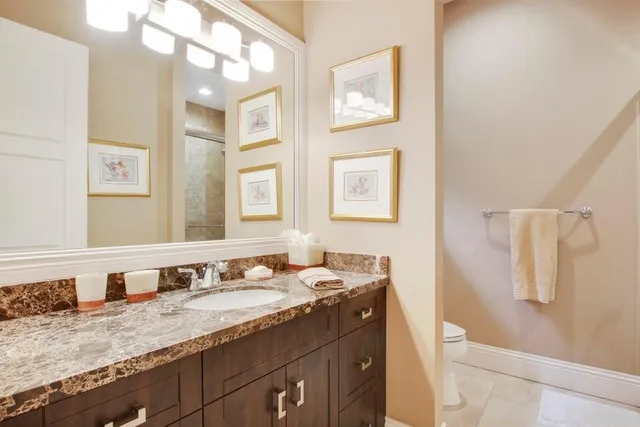 a bathroom with a granite countertop sink and a mirror