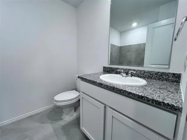 a bathroom with a granite countertop sink and a mirror