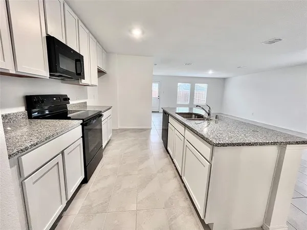 a kitchen with granite countertop a sink and steel appliances