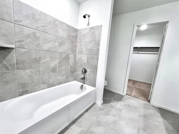 a spacious bathroom with a bathtub and shower