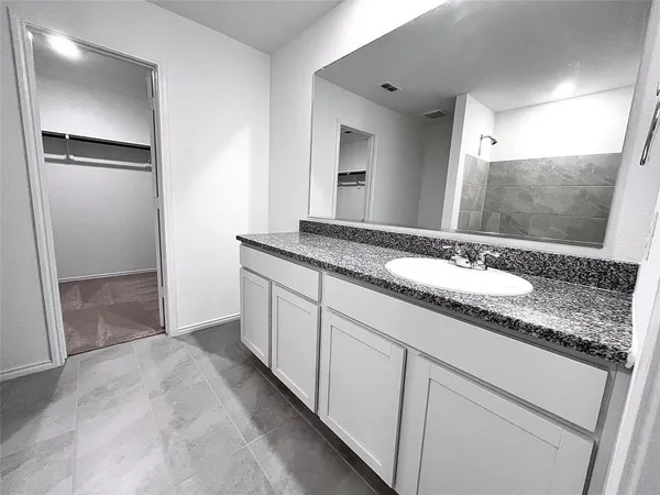 a bathroom with a granite countertop sink and a mirror