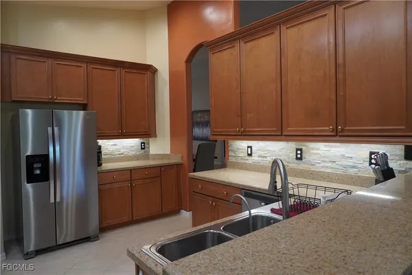 a kitchen with stainless steel appliances granite countertop a refrigerator and a sink