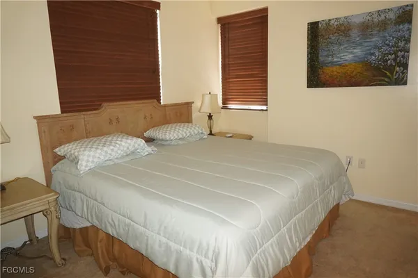 a bedroom with a bed and a painting on the wall