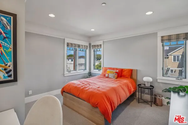 a bedroom with a bed and a painting on the wall