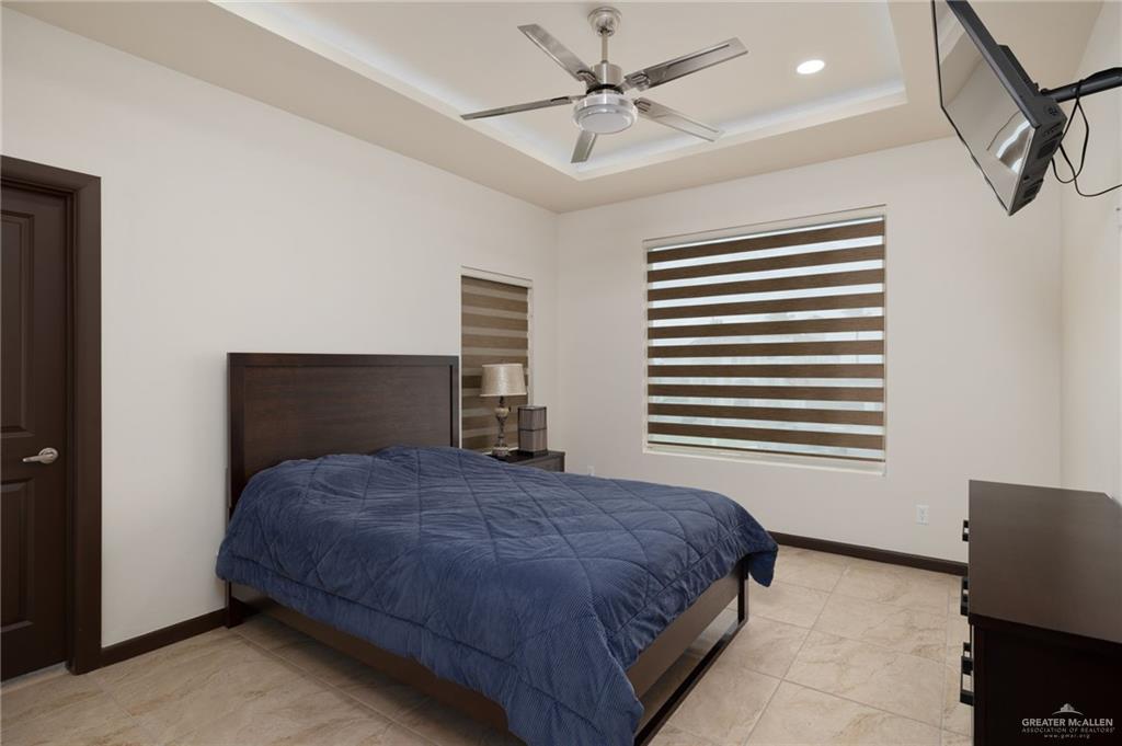 2615 South 43 Rd Lane McAllen, TX 78503 - Photo 15 of 22 a bedroom with a bed and a chandelier