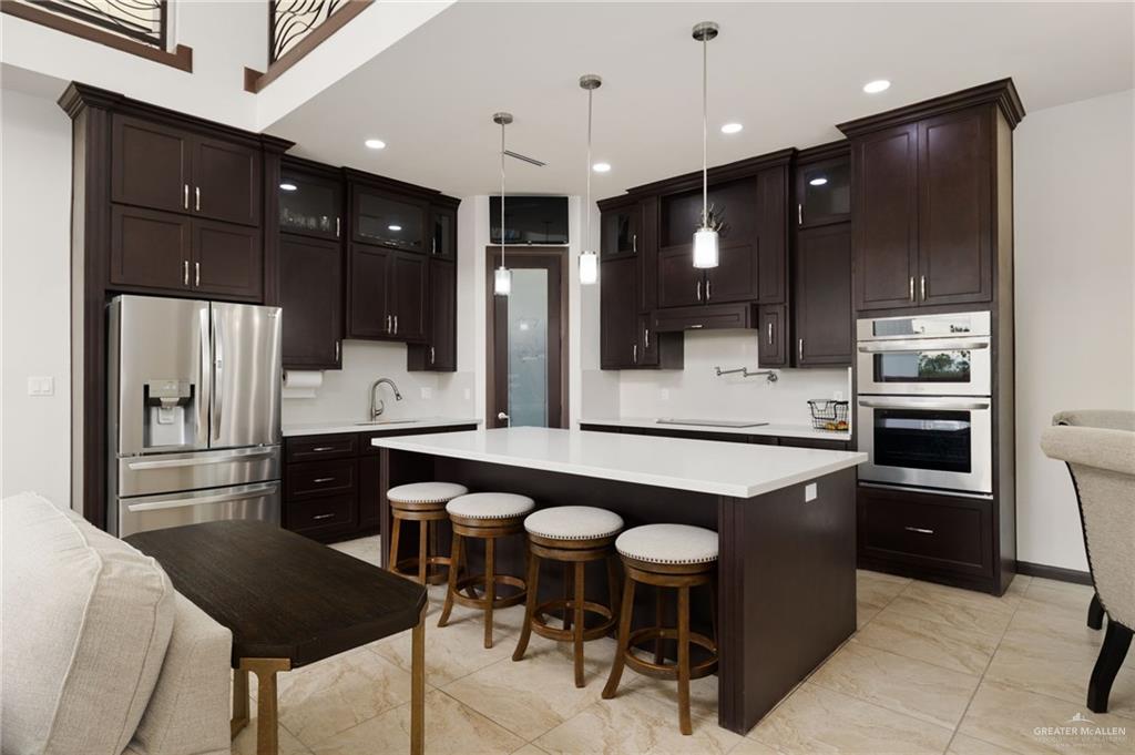 2615 South 43 Rd Lane McAllen, TX 78503 - Photo 6 of 22 a kitchen with stainless steel appliances kitchen island granite countertop a refrigerator and a stove top oven