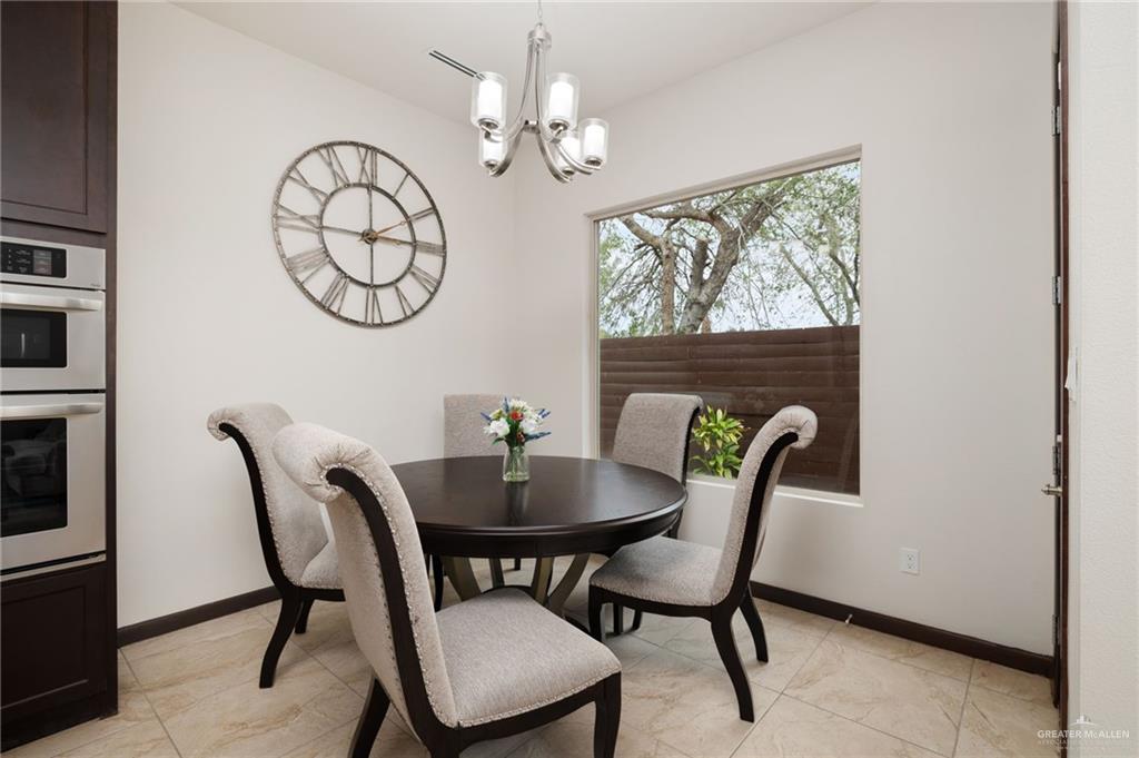 2615 South 43 Rd Lane McAllen, TX 78503 - Photo 7 of 22 a dining room with furniture a rug a potted plant and a chandelier