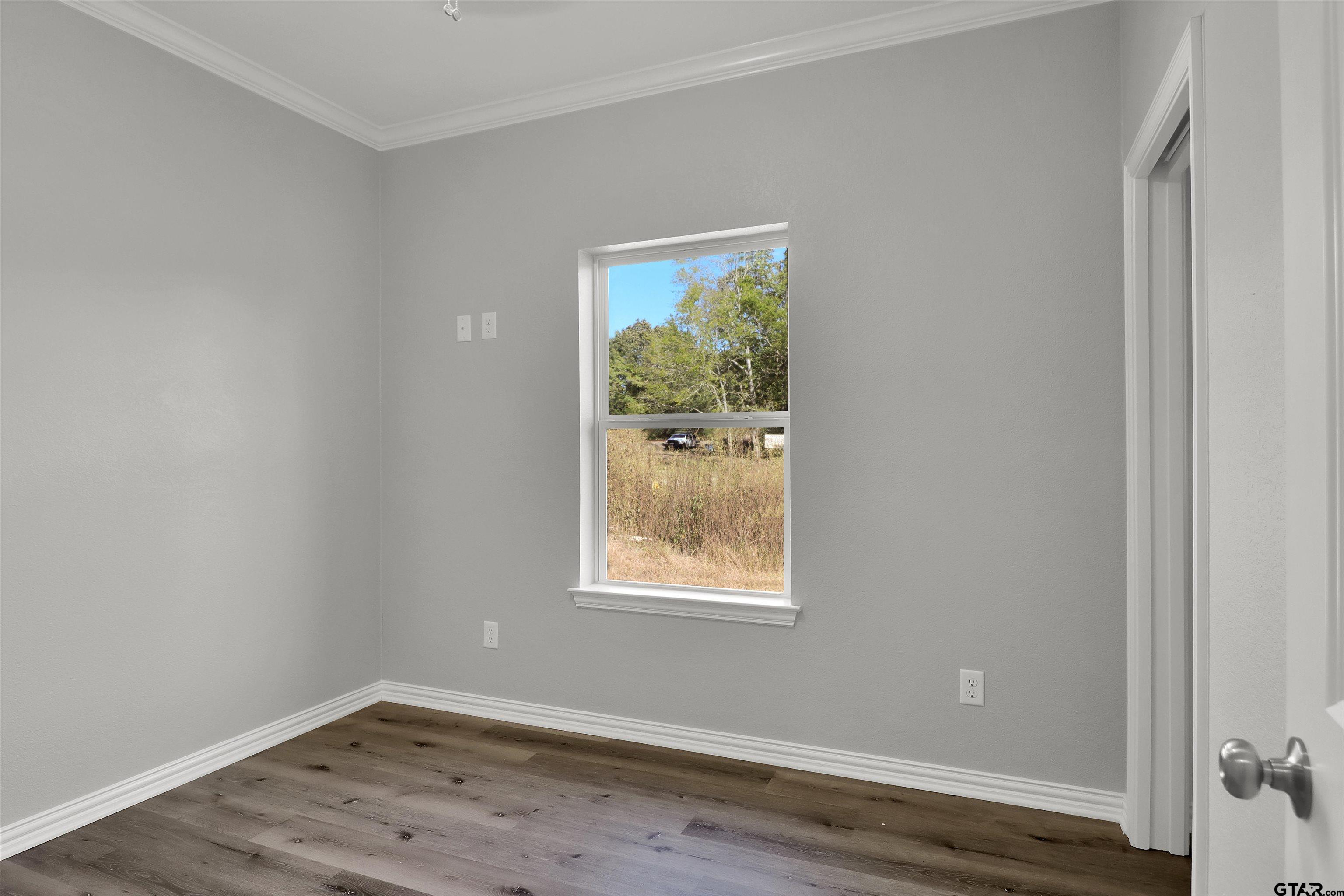 614 North Commerce Street Overton, TX 75684 - Photo 15 of 24 a view of an empty room with wooden floor and a window