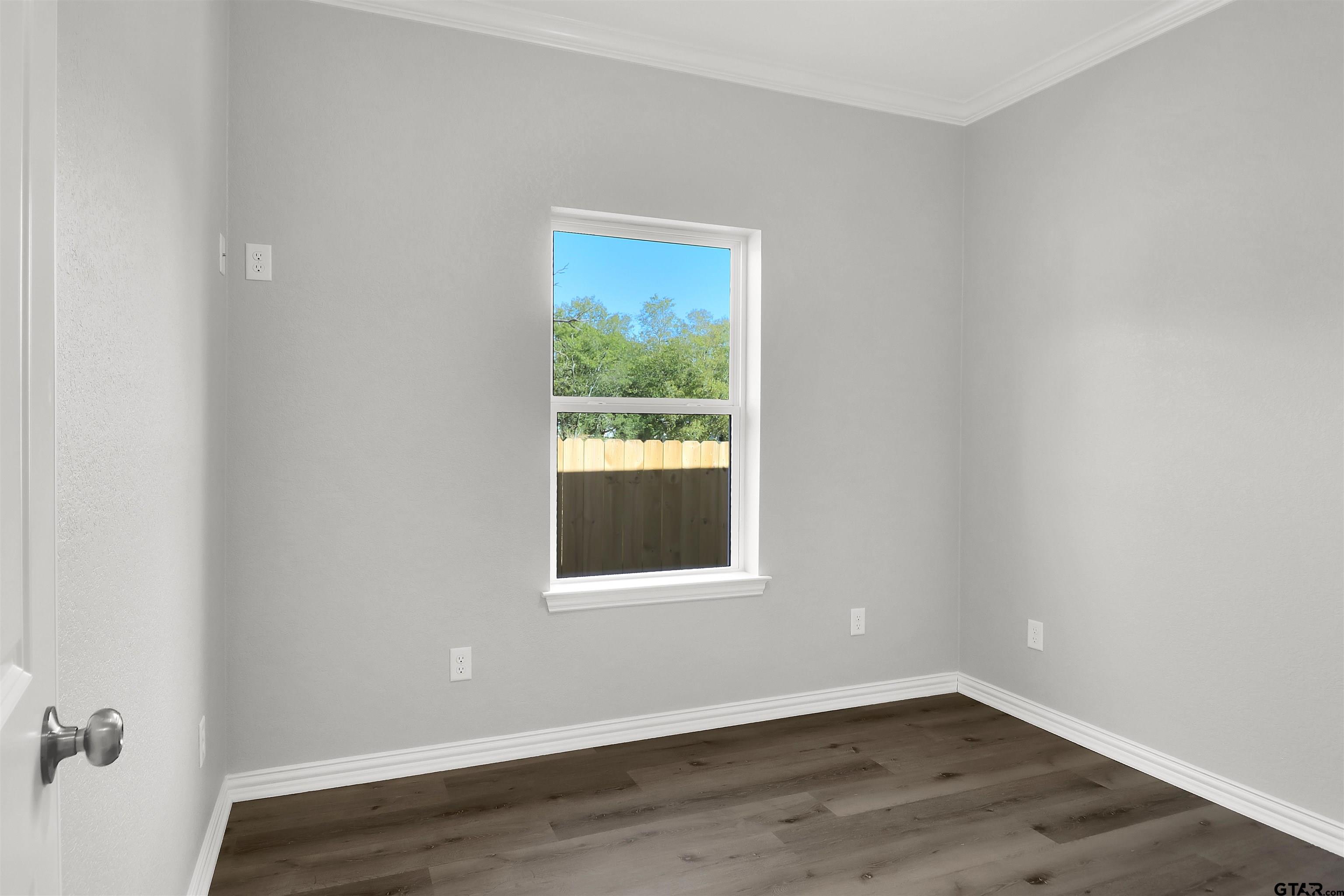 614 North Commerce Street Overton, TX 75684 - Photo 17 of 24 a view of an empty room with wooden floor and a window