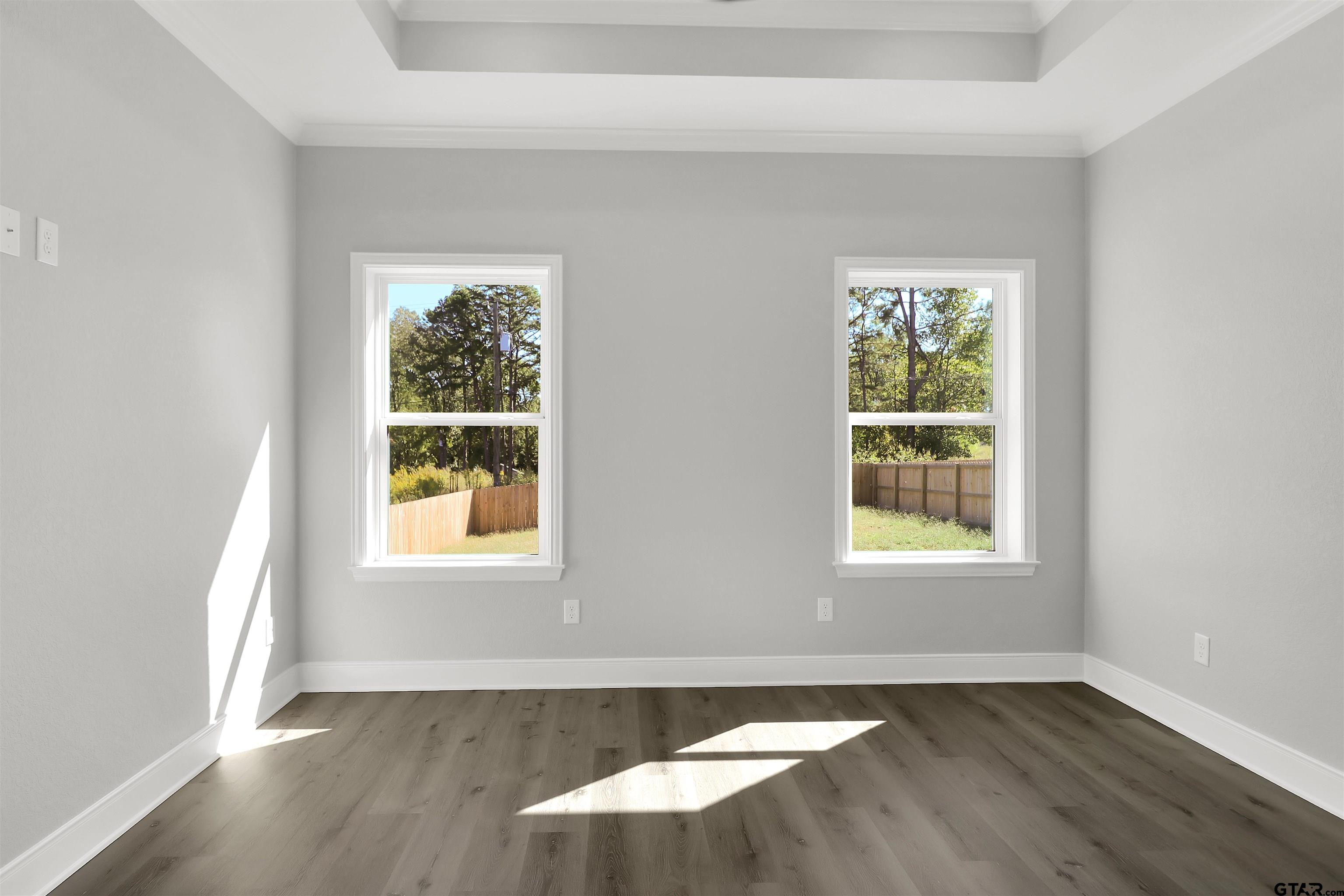 614 North Commerce Street Overton, TX 75684 - Photo 18 of 24 an empty room with wooden floor and windows