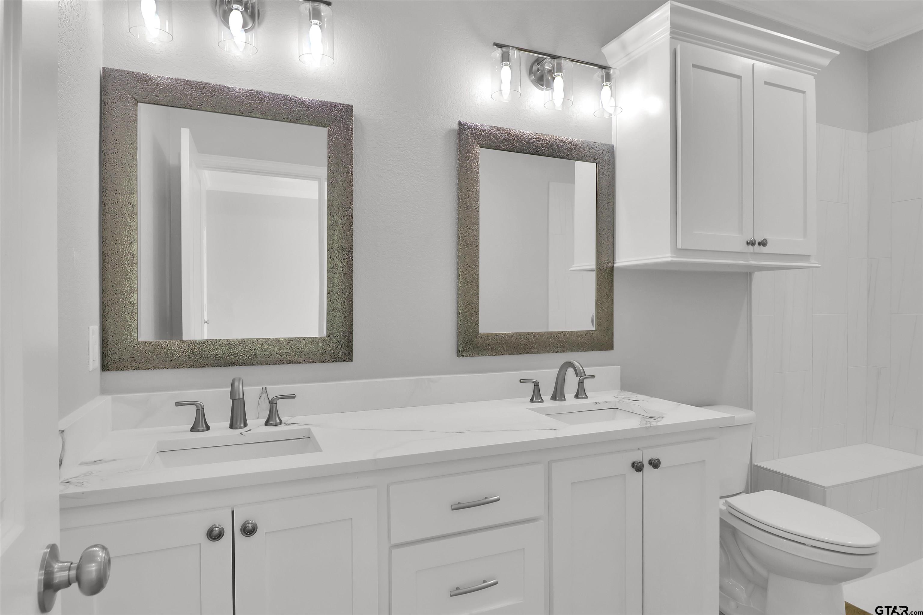614 North Commerce Street Overton, TX 75684 - Photo 20 of 24 a bathroom with double sink and a mirror