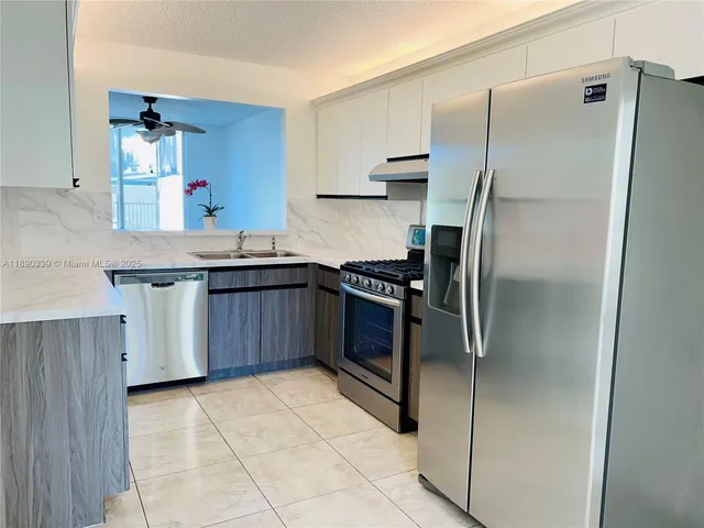 a kitchen with a refrigerator a sink and cabinets