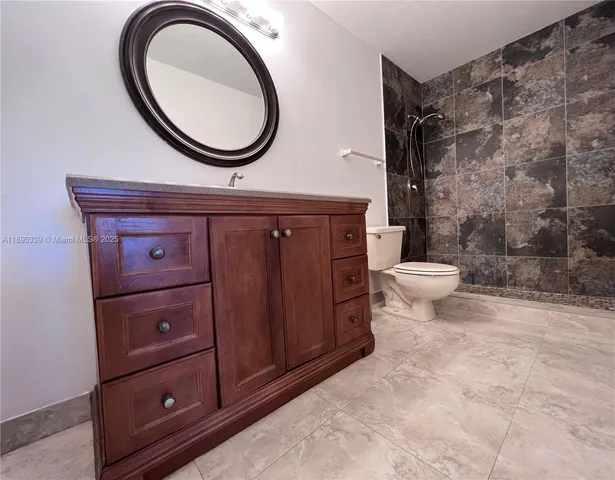 a bathroom with a toilet a sink a mirror and a shower