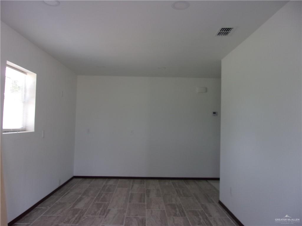 5 Mile Line Road Mission, TX 78573 - Photo 2 of 9 a view of an empty room with wooden floor and a window