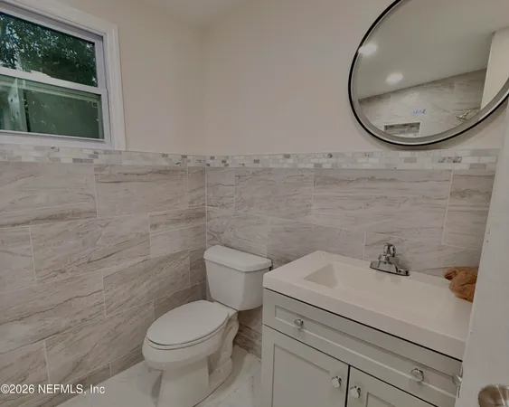 a bathroom with a toilet sink and mirror