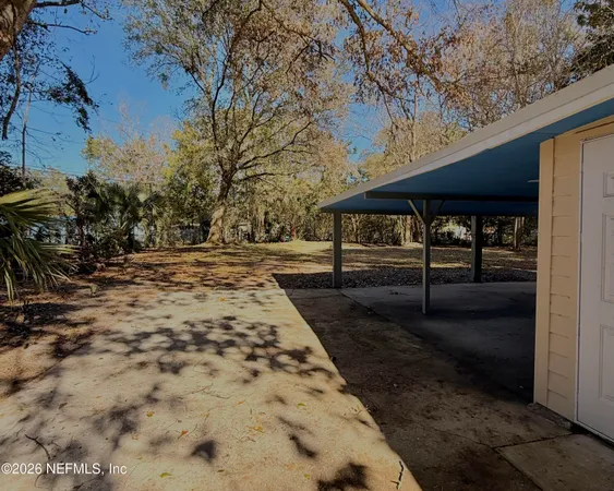 a backyard of a house with barbeque oven table and chairs