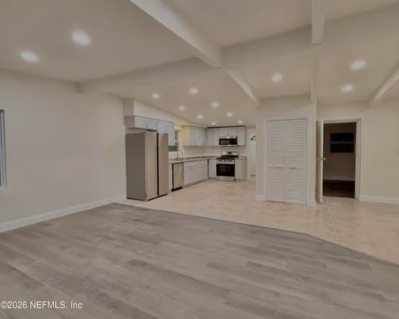 a view of kitchen with refrigerator and microwave