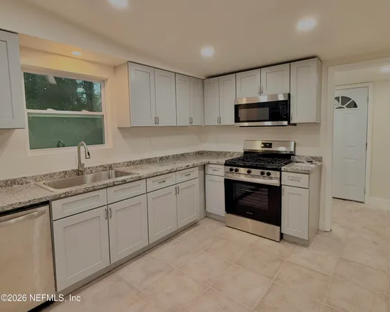 a kitchen with stainless steel appliances granite countertop a sink and a stove top oven