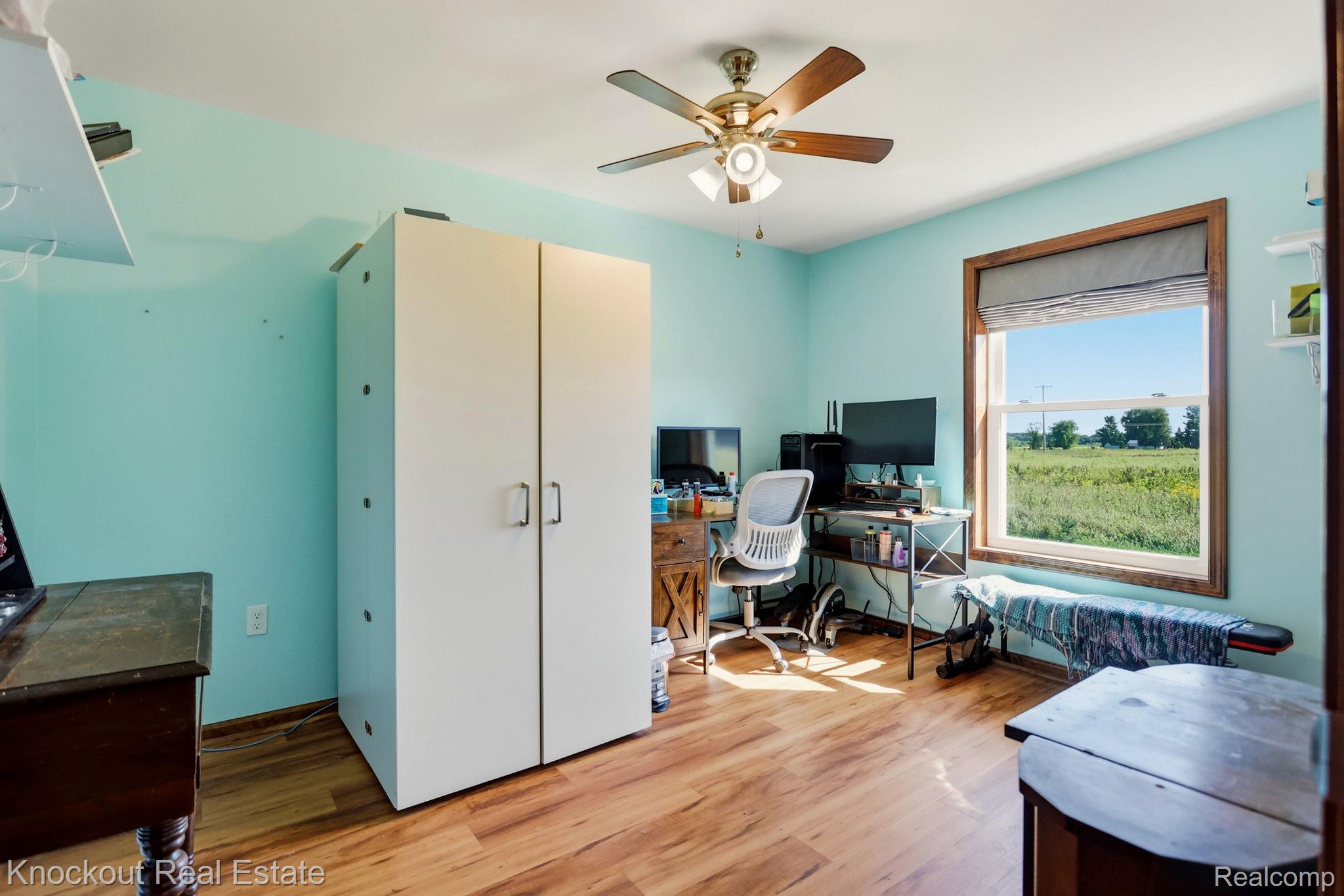 5727 Mackinaw Road Saginaw, MI 48604 - Photo 32 of 60 Wood-finish flooring throughout, bright window with wood trim, ceiling fan light fixture, and built-in white cabinetry