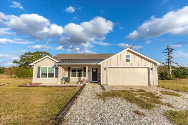 a kitchen with stainless steel appliances kitchen island granite countertop a refrigerator a stove a sink a dining table and chairs with wooden floor