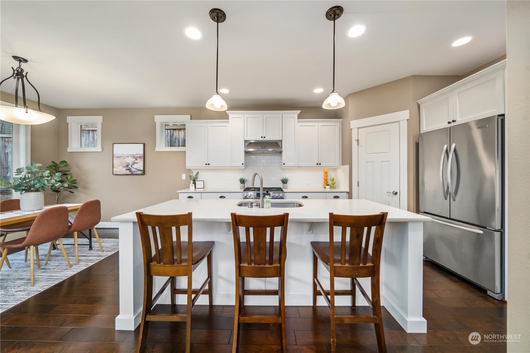 5514 Northeast 7th Place Renton, WA 98059 - Photo 8 of 36 a kitchen with stainless steel appliances granite countertop a dining table chairs refrigerator and sink