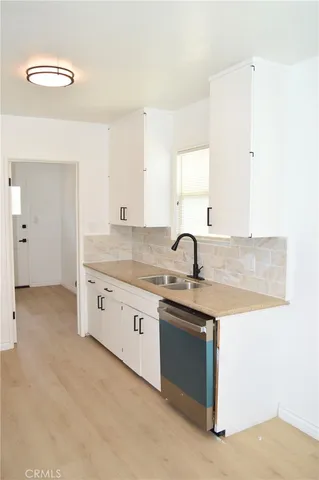 a kitchen with granite countertop a sink and cabinets