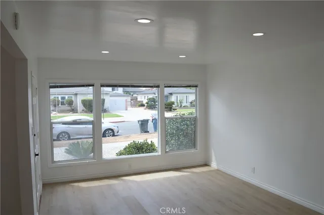 a view of a livingroom with wooden floor and a large window