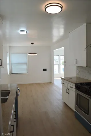 a kitchen with granite countertop white cabinets and window