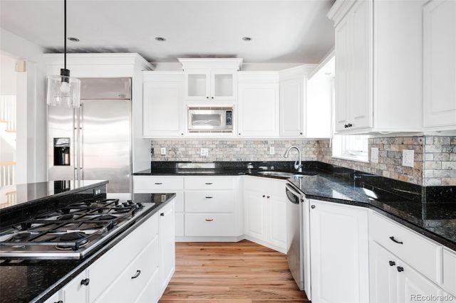 a kitchen with stainless steel appliances a sink stove and cabinets