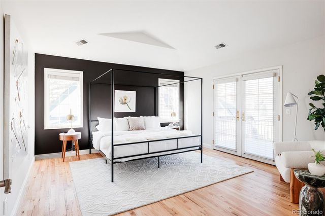 a white bed sitting in a bedroom next to a window