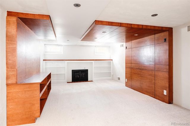 a view of empty room with cabinet and fireplace