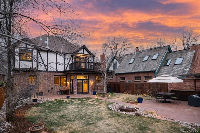 a view of a big house with wooden fence
