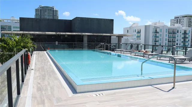 a view of swimming pool with outdoor seating and buildings in the background