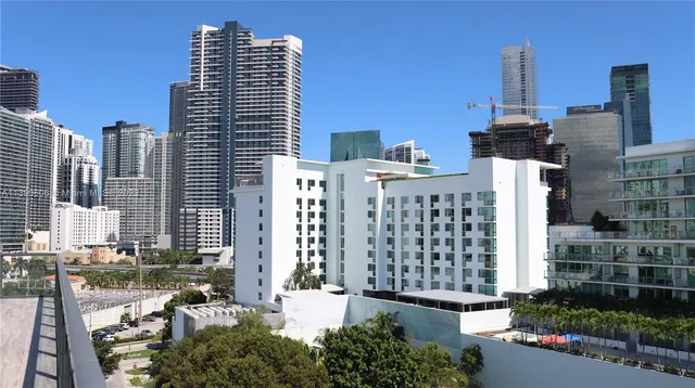 a front view of a building with glass windows and trees