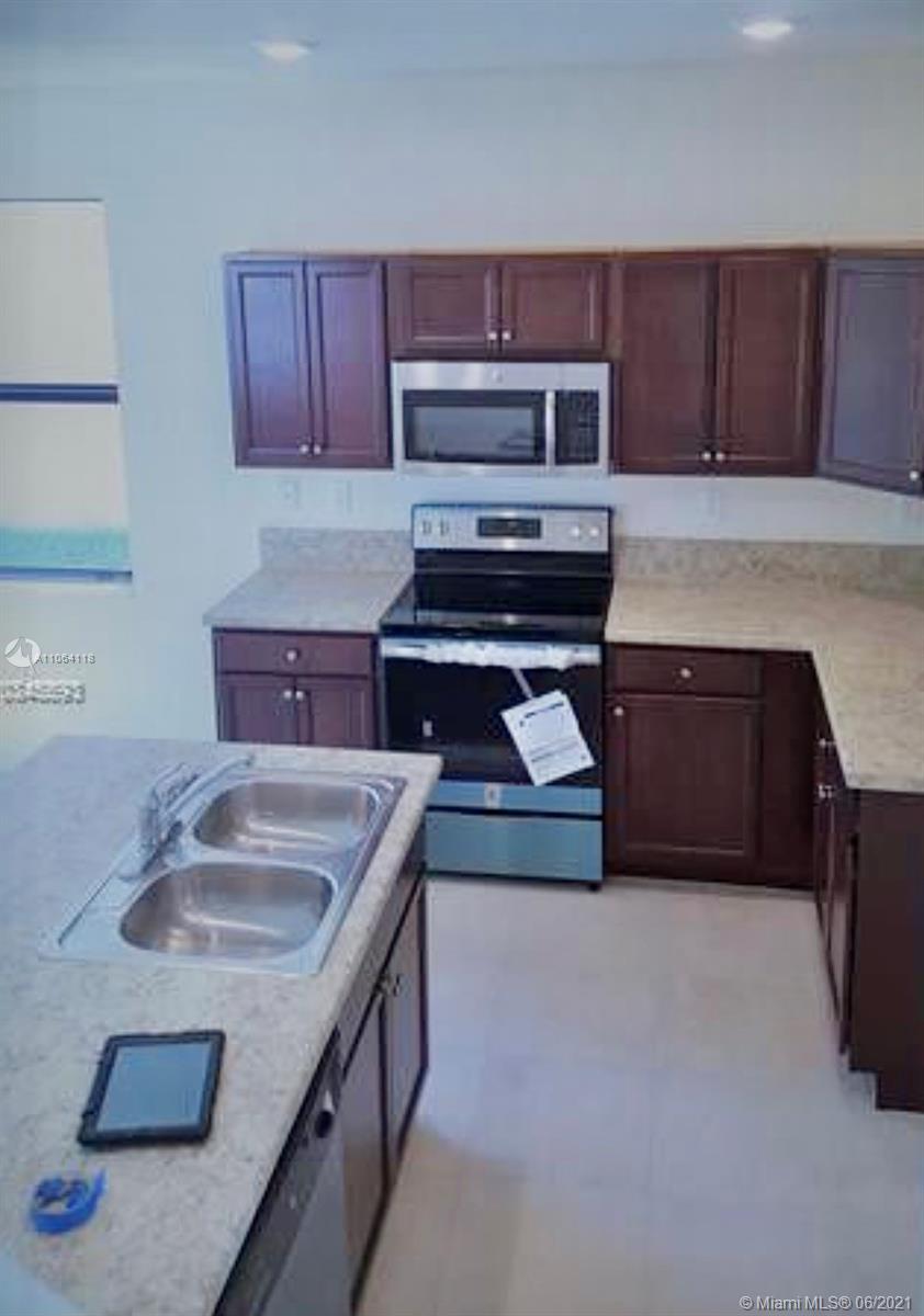 3771 Northeast 1st Street Homestead, FL 33033 - Photo 4 of 7 a kitchen with sink cabinets and stainless steel appliances