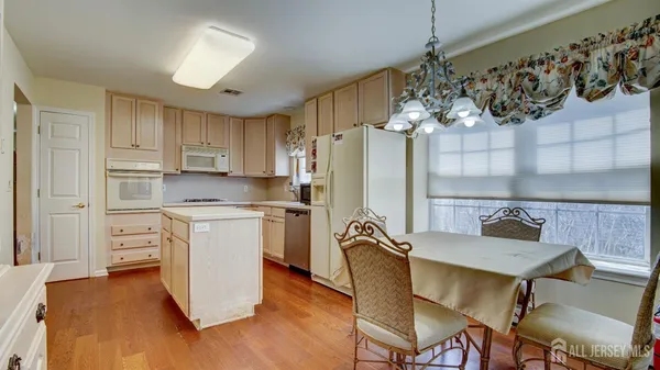 a kitchen with stainless steel appliances a dining table chairs and chandelier