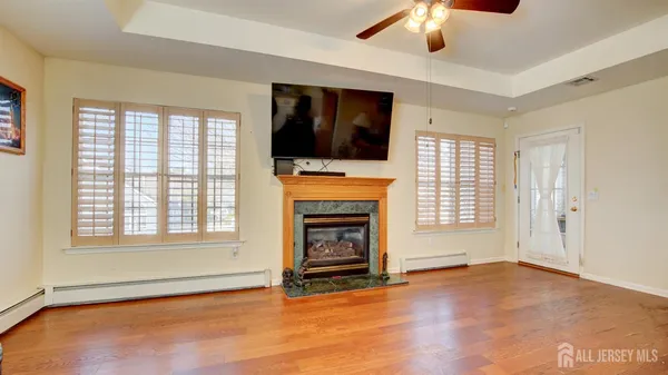 an empty room with windows fireplace and cabinet