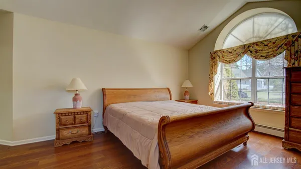 a bedroom with a bed and wooden floor