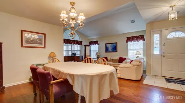 a view of a dining room with furniture wooden floor and chandelier
