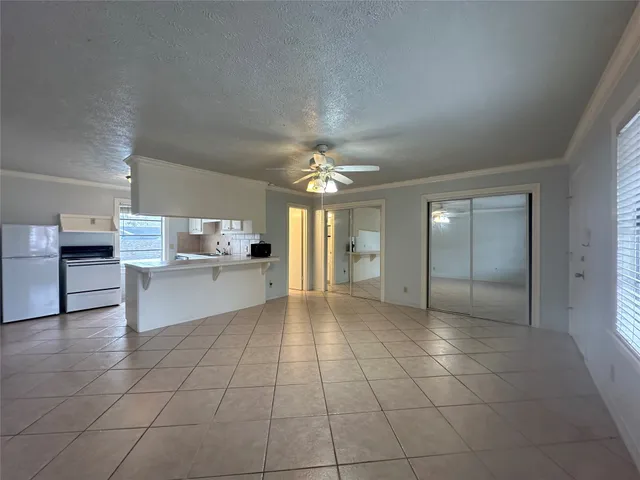 a view of a kitchen with kitchen island granite countertop a refrigerator sink and cabinets