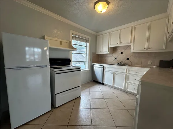 a kitchen with granite countertop a refrigerator and a stove top oven