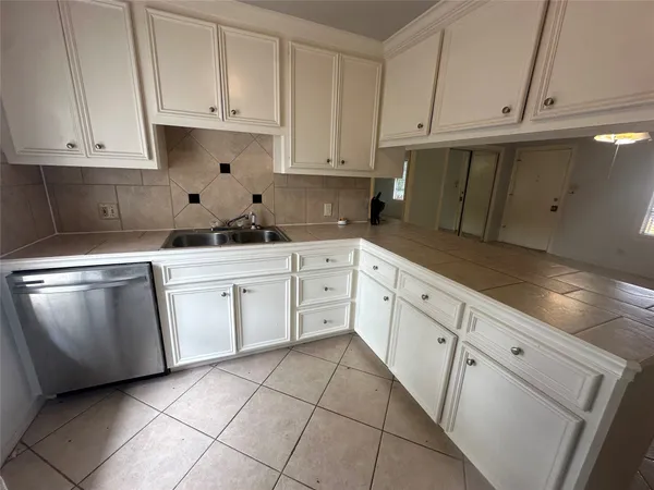 a kitchen with white cabinets and white appliances