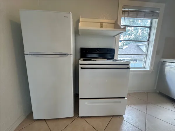 a white refrigerator freezer and a stove sitting inside of a kitchen