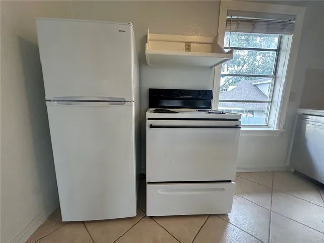 a white refrigerator freezer and a stove sitting inside of a kitchen