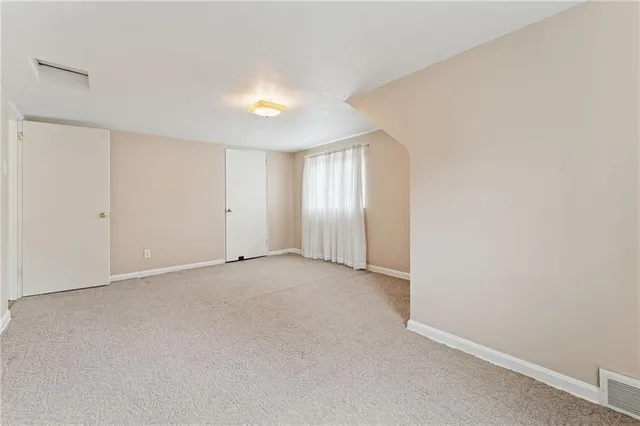 an empty room with windows and closet