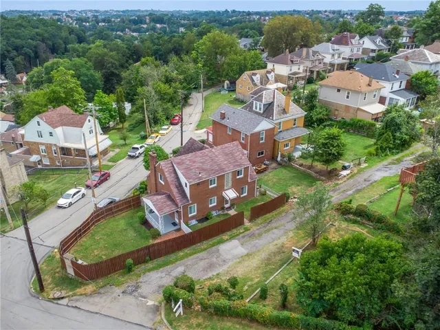 an aerial view of residential houses with outdoor space and river view