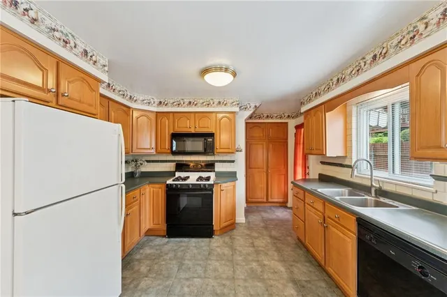 a kitchen with stainless steel appliances granite countertop a refrigerator a stove top oven a sink and dishwasher